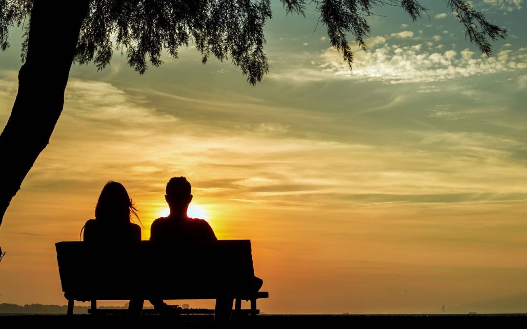 couple on bench watching sunset